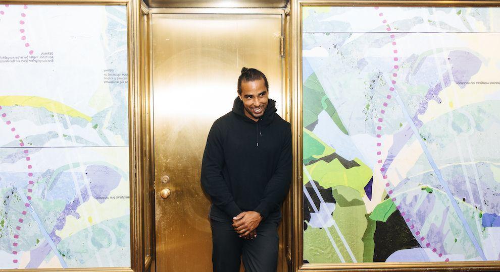 Artist Hugo McCloud stands in front of his artwork on display at Rockefeller Center