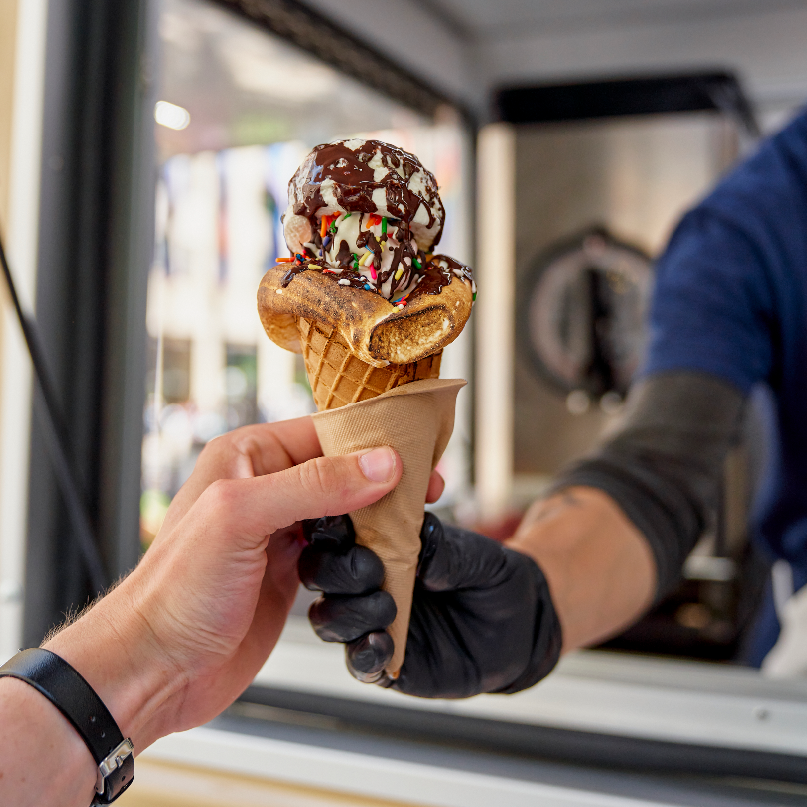 Two hands holding an ice cream cone from Glace's ice cream truck at Rockefeller Center