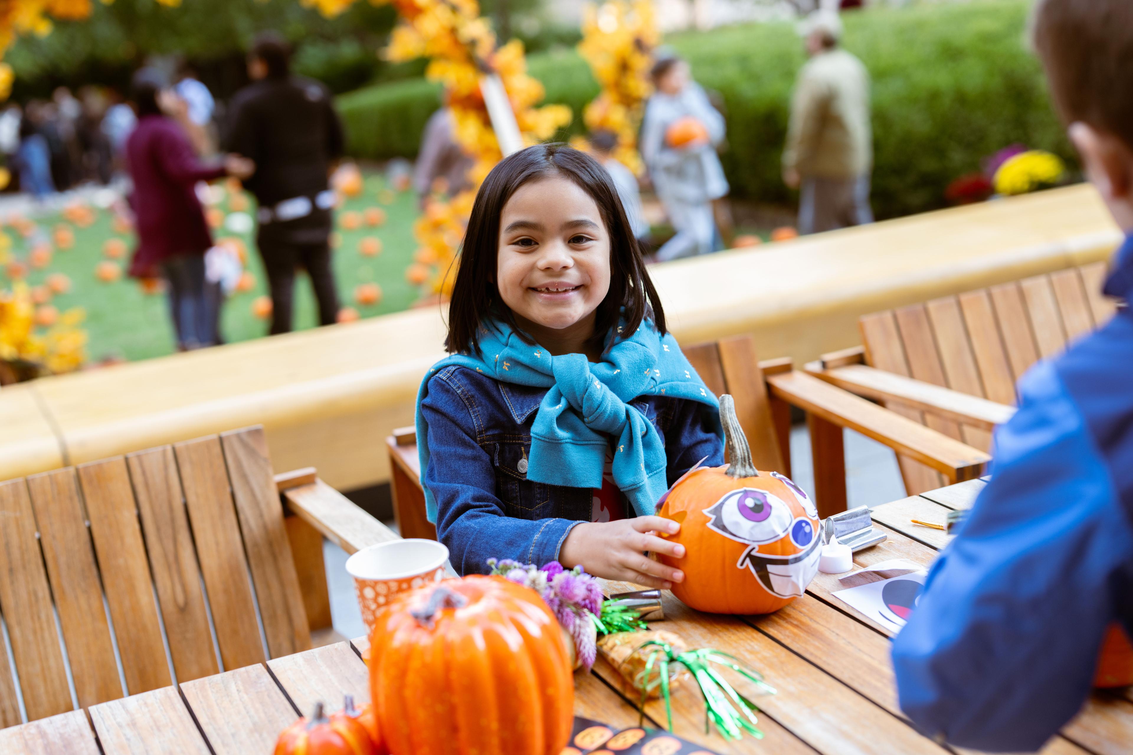 A child painting a pumpkin at Rockefeller Center