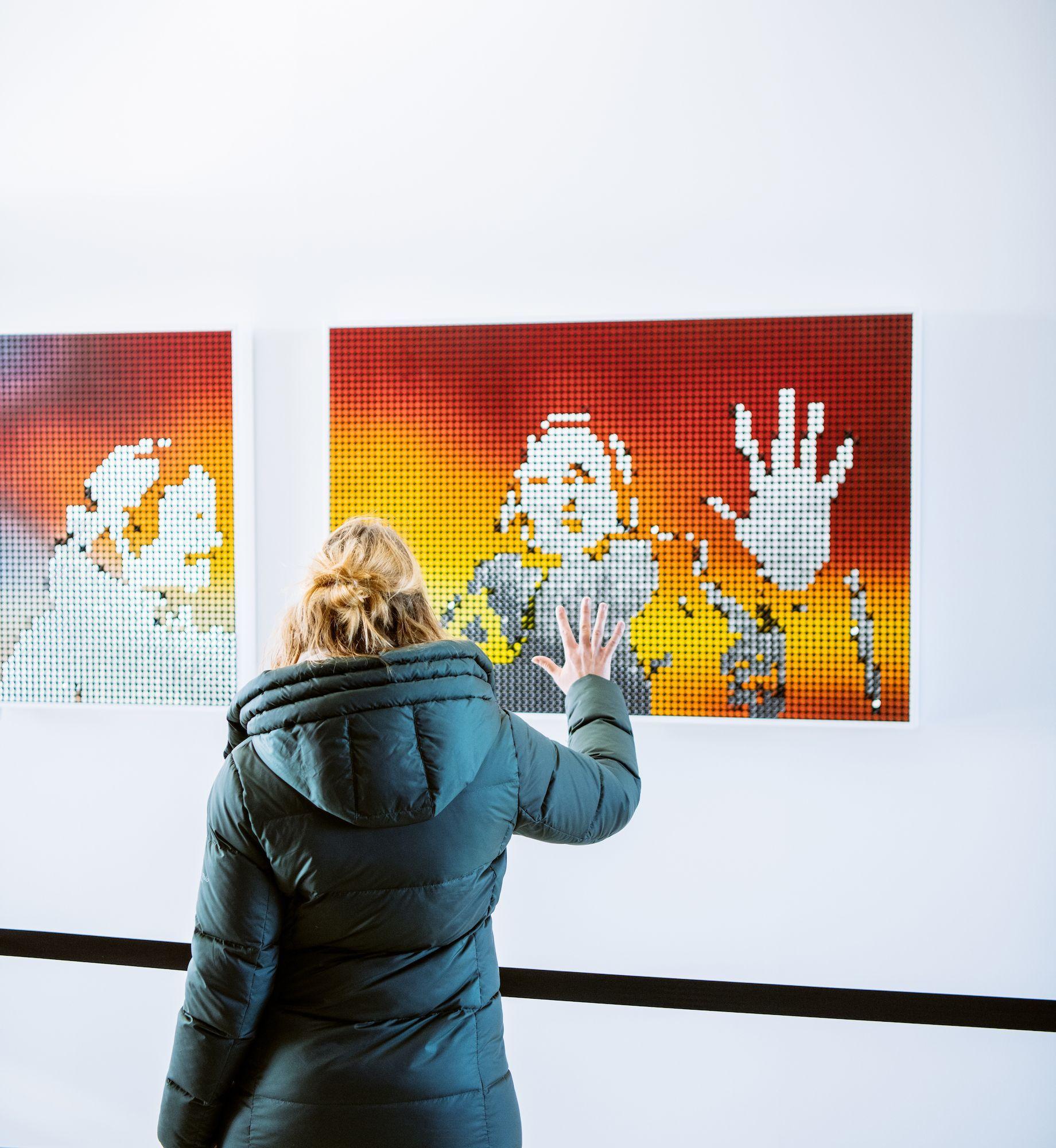 Person interacting with Breakfast Studio's kinetic sculpture in Top of the Rock's "New Frontiers" exhibit