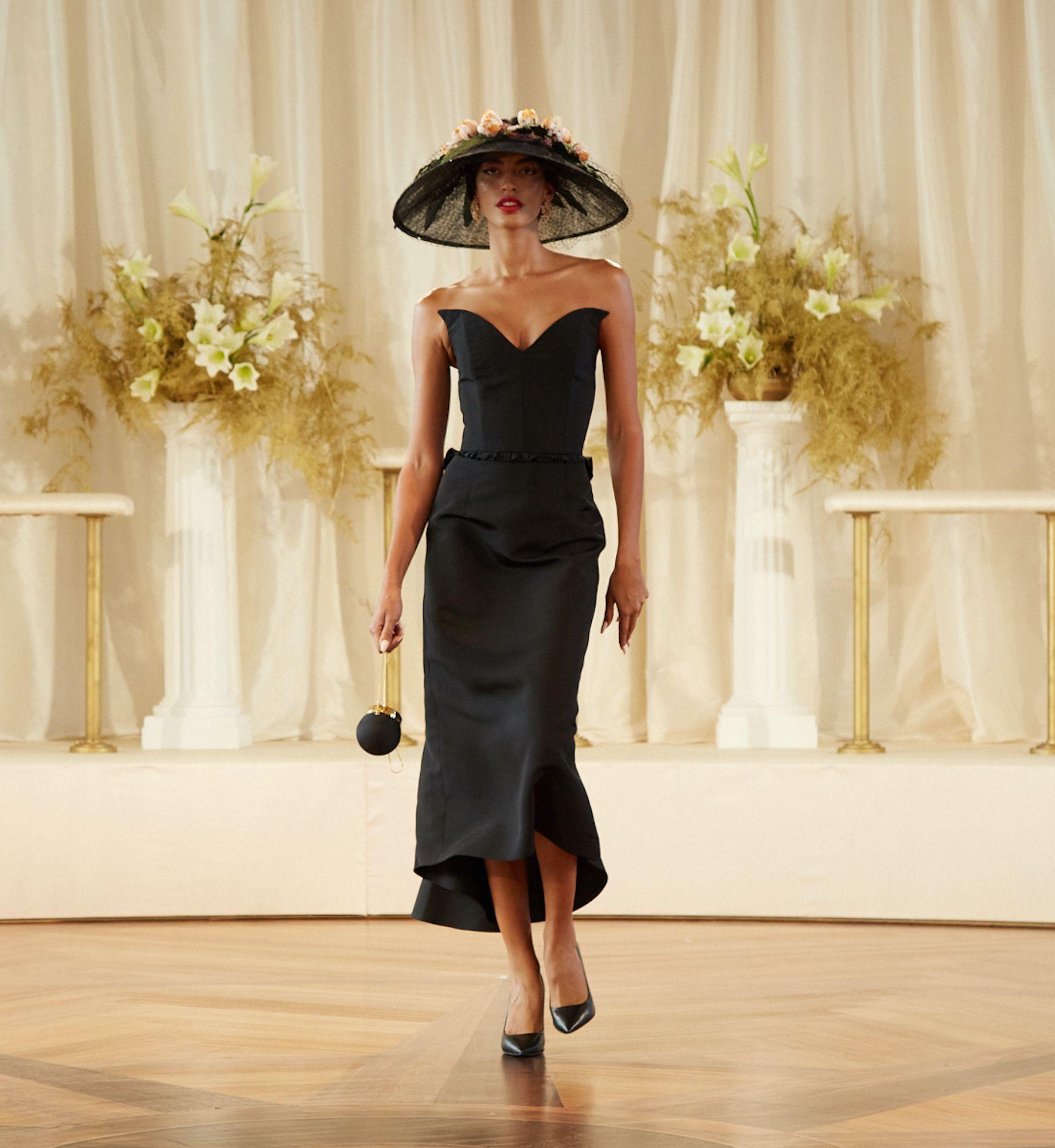 Model in a black dress and hat in Markarian's Spring/Summer 2022 runway show at the Rainbow Room
