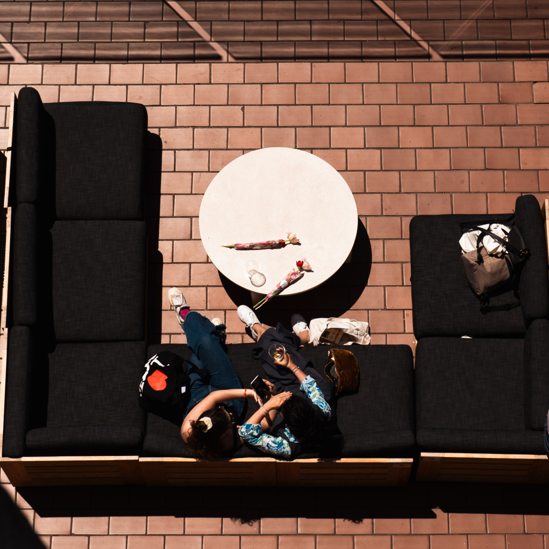 Two people sitting on couches on The Weather Room's outdoor terrace