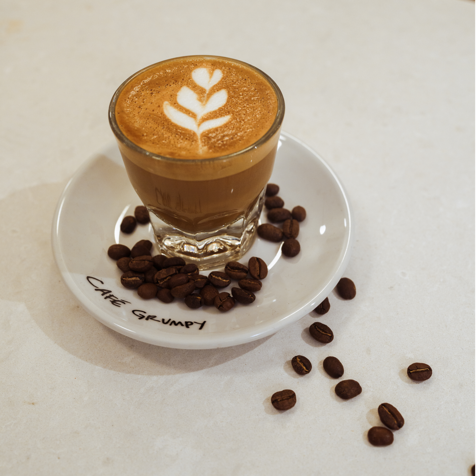 Cup of espresso with scattered coffee beans from Cafe Grumpy at Rockefeller Center