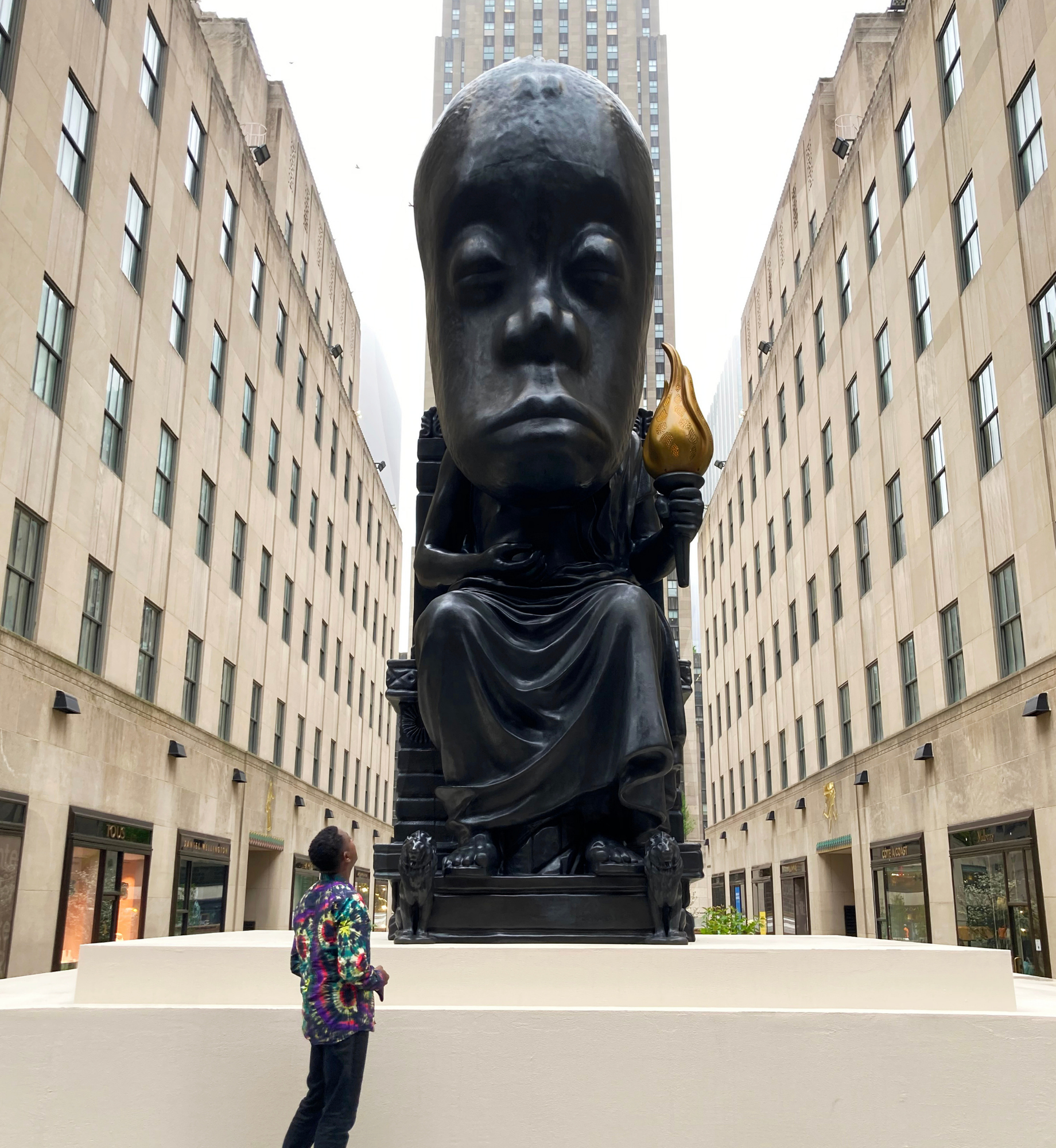 Sanford Biggers standing in front of the Oracle statue at Rockefeller Center