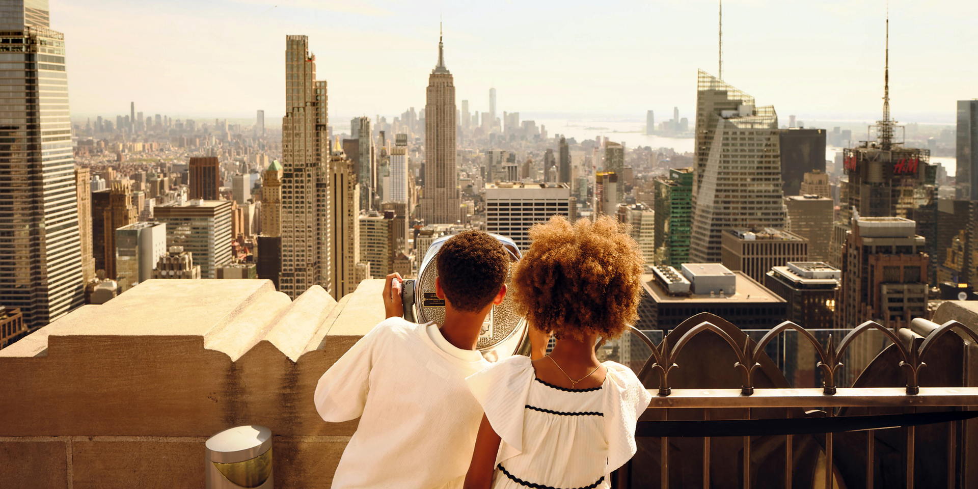 two kids looking at new york city skyline from top of the rock observation deck