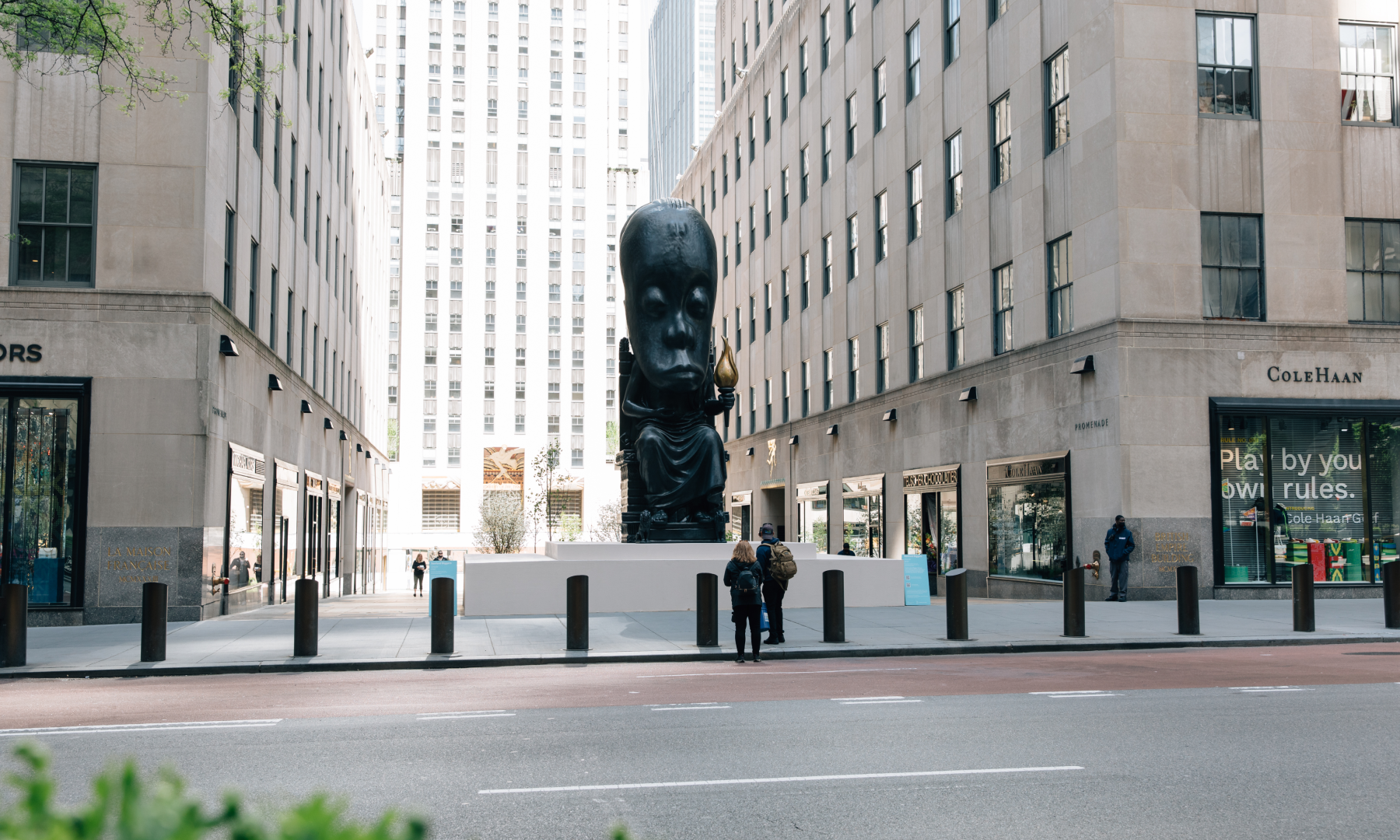 A zoomed out view of Sanford Biggers' "Oracle" statue on display in the Channel Gardens at Rockefeller Center