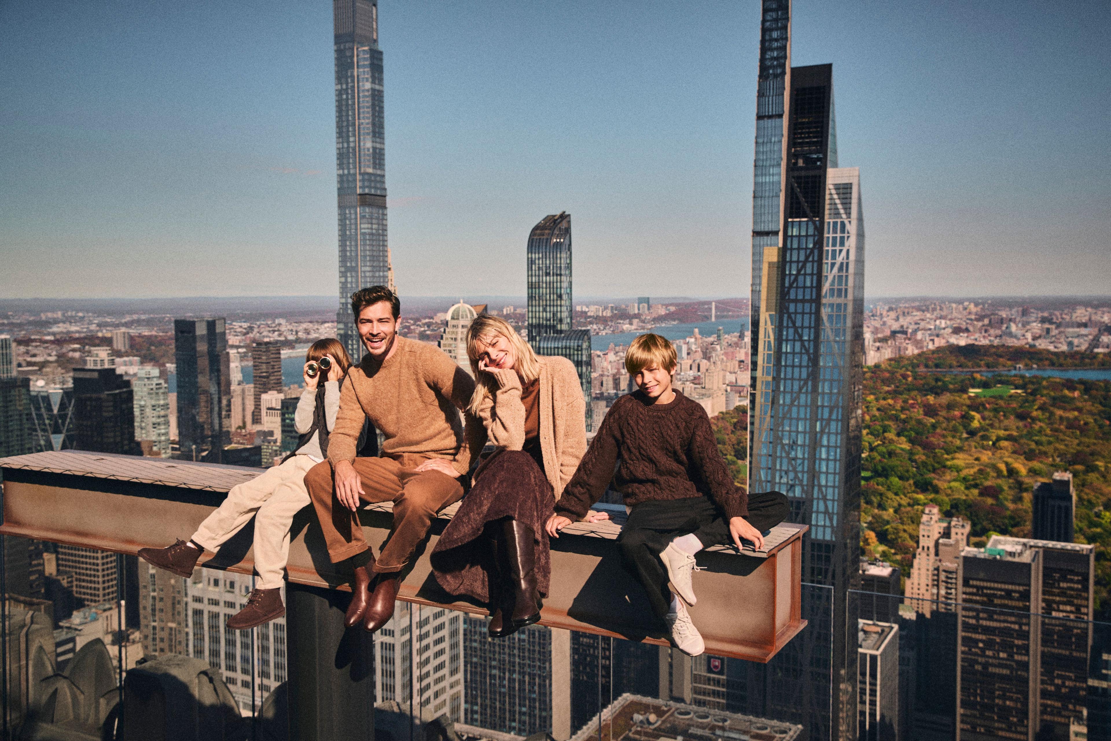 a family on the beam at top of the rock