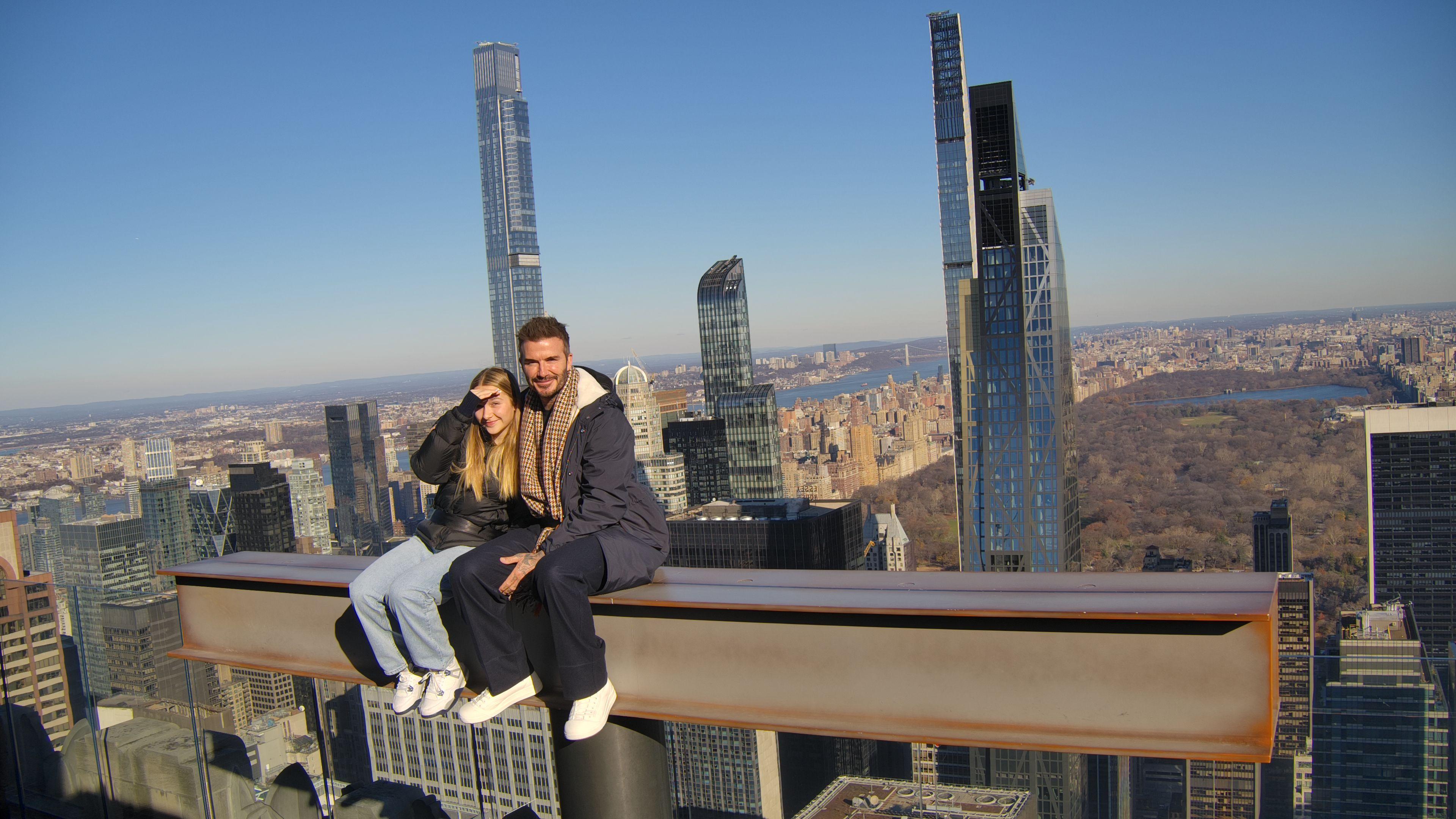 david beckham and his daughter on the beam at top of the rock
