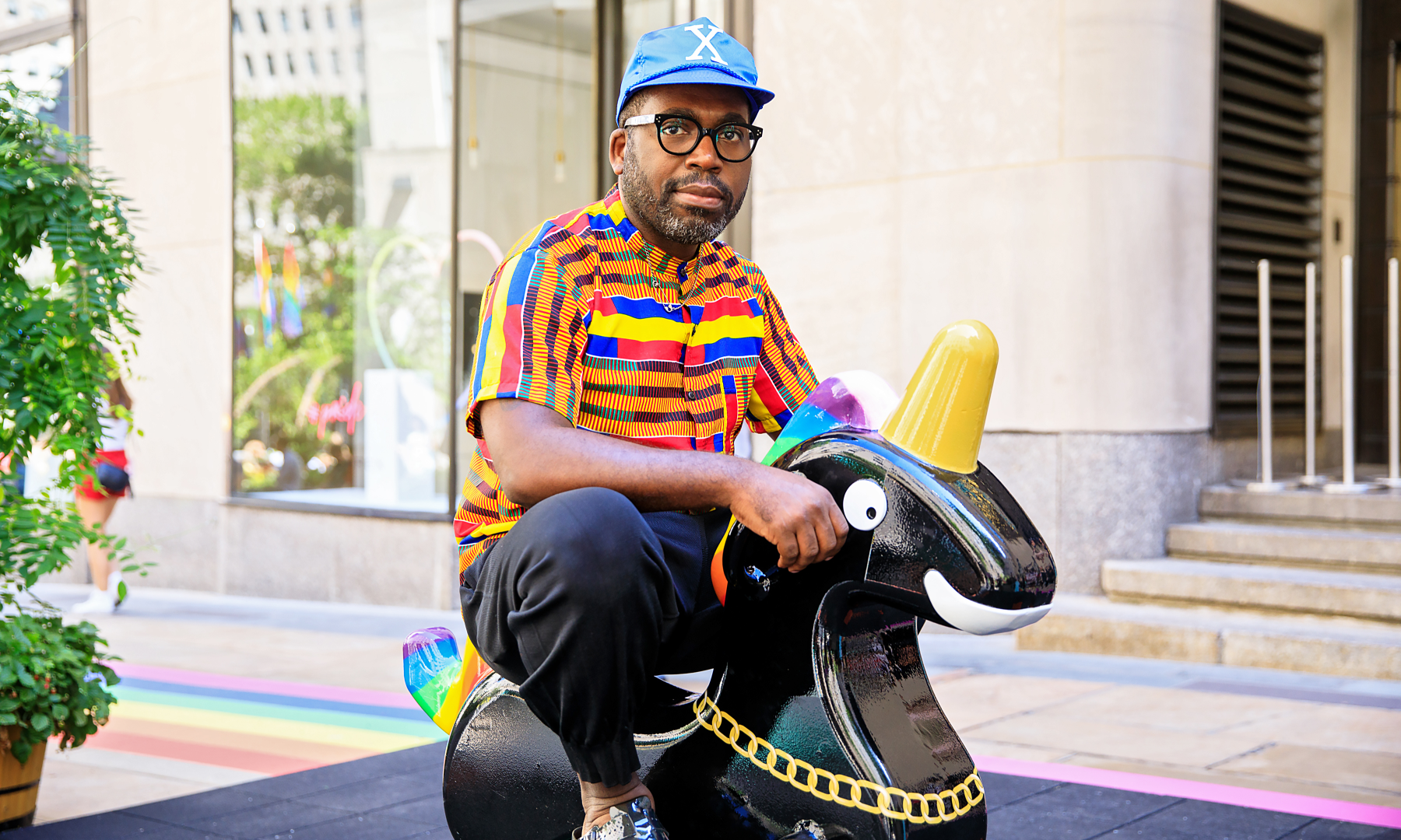 Artist Derrick Adams posing with his "Funtime Unicorns" exhibit at Rockefeller Center