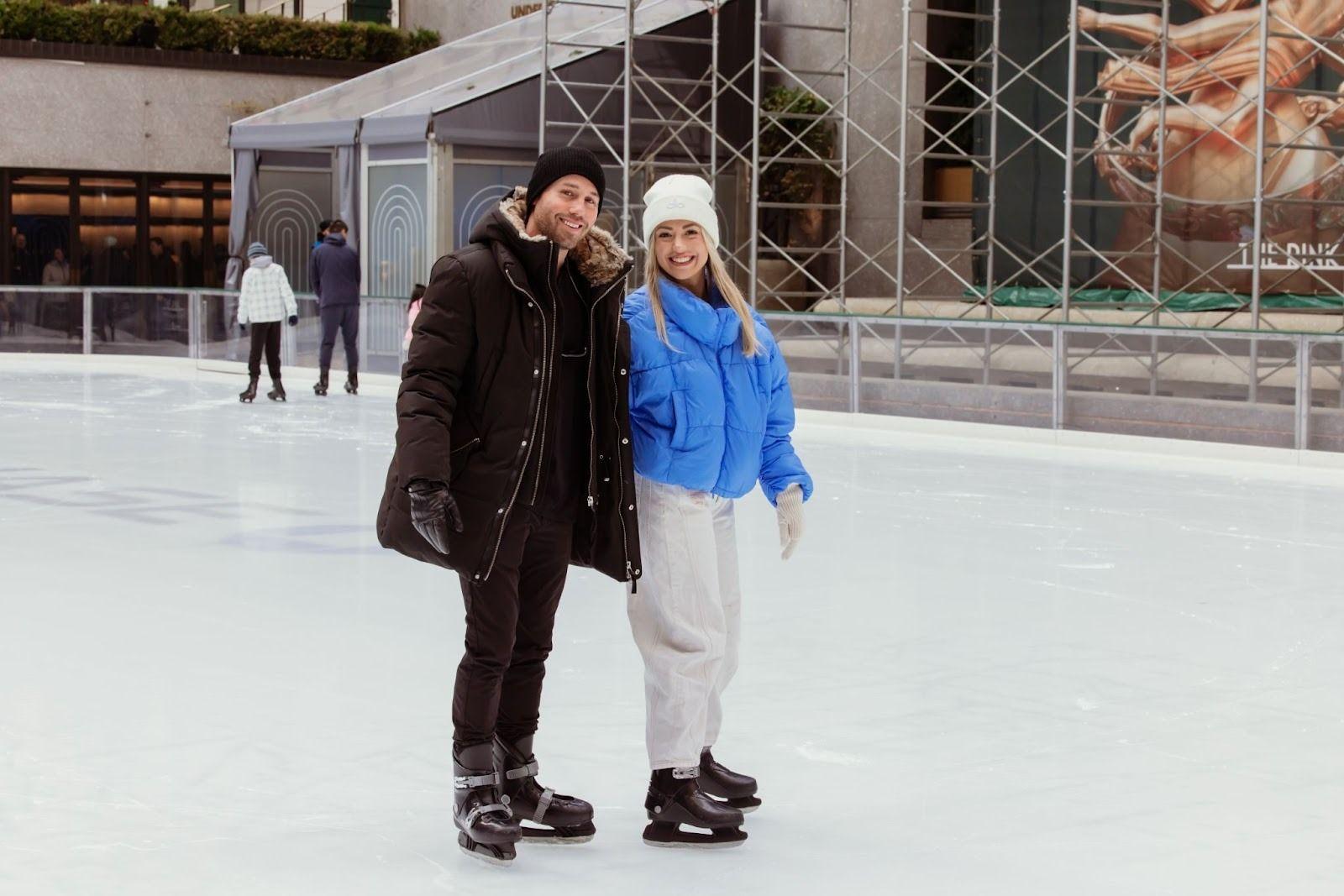 two skaters in warm clothing at The Rink at Rockefeller Center