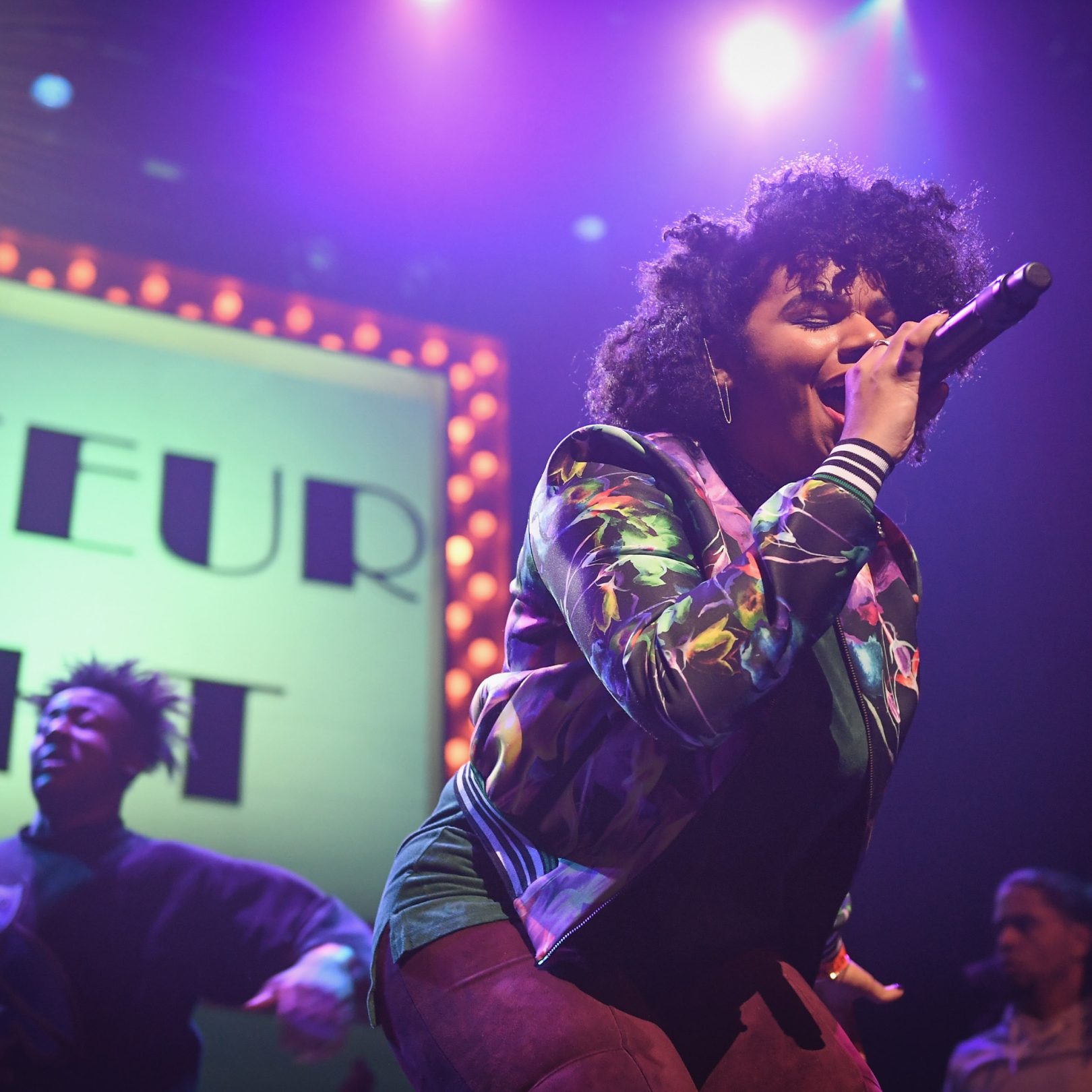 A woman singing onstage at the Apollo Theater during Amateur Night