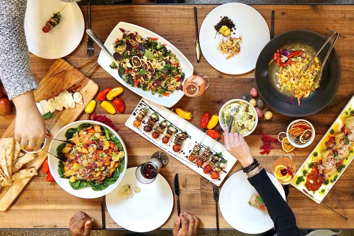 Savory spread of food with three sets of hands
