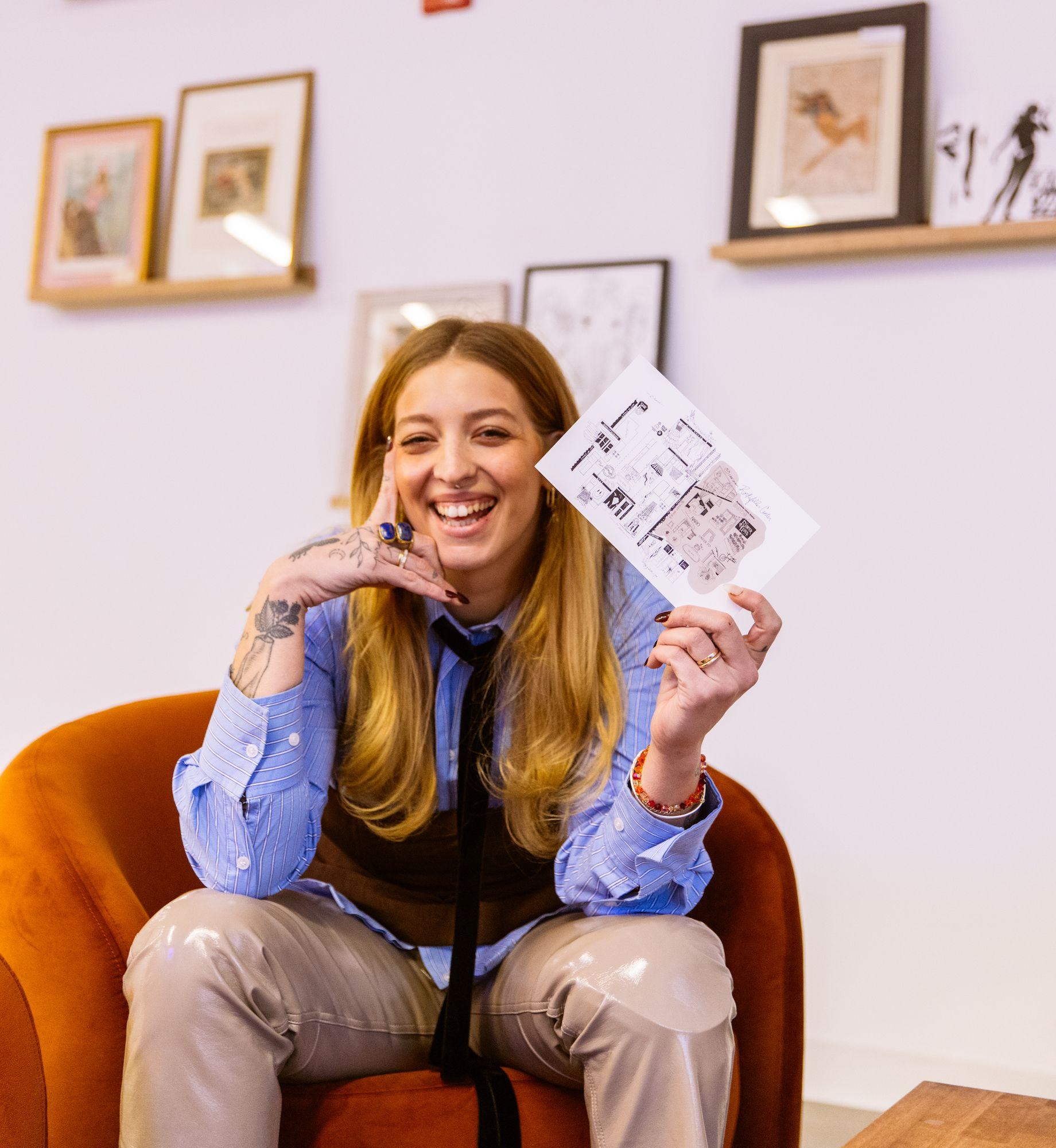 Mira Mariah of Girl Knew York holding a map she designed of women-owned businesses at Rockefeller Center
