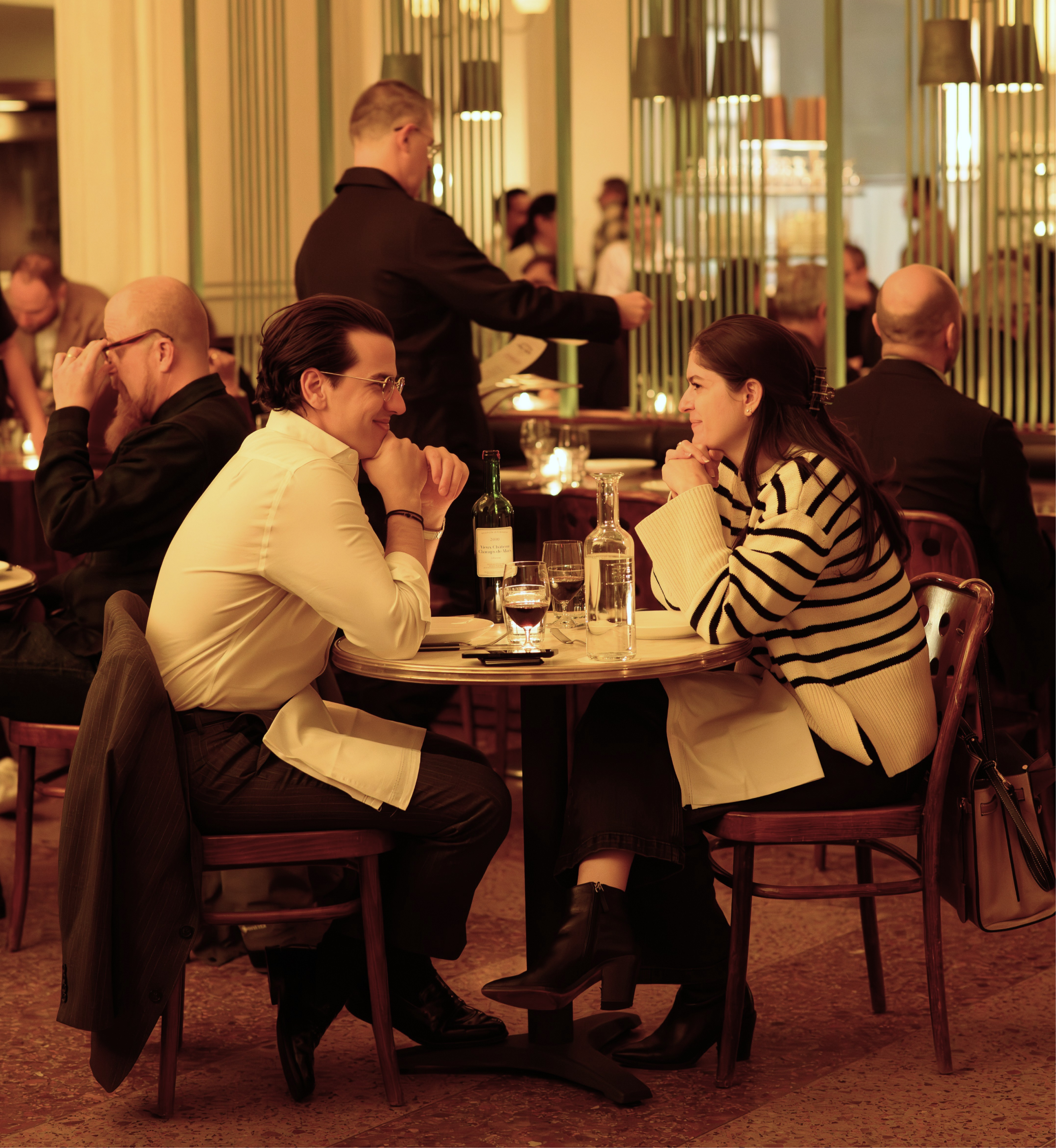 A man and a woman seated at a table inside Le Rock at Rockefeller Center