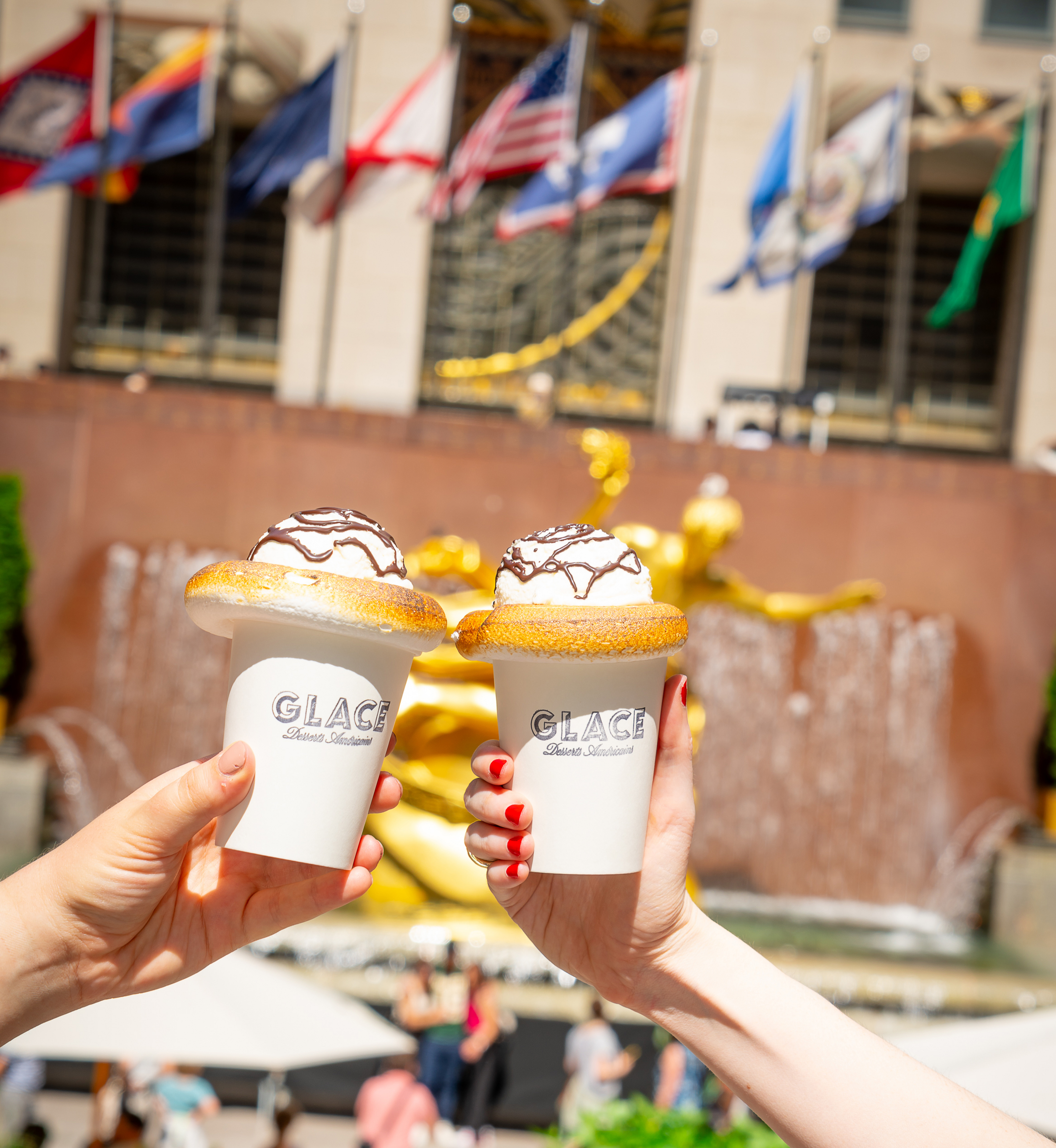 Two hands holding frozen desserts from Glace at Rockefeller Center