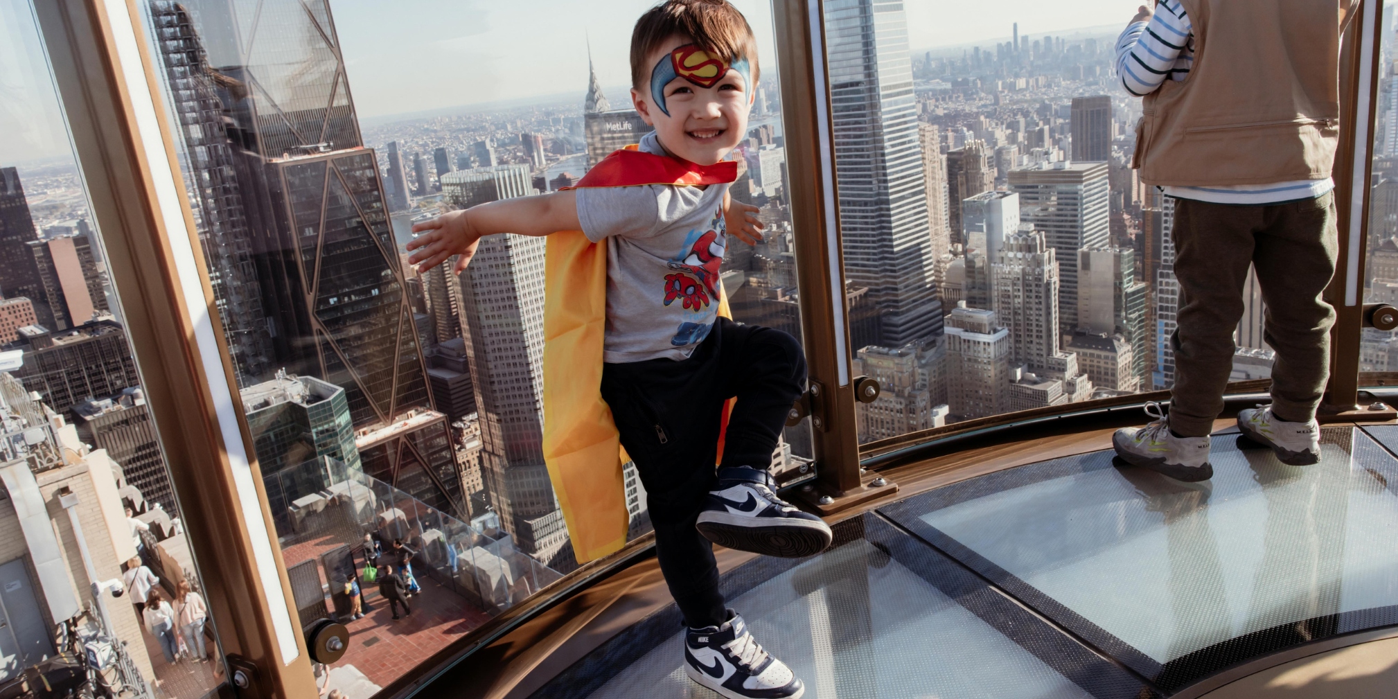 a kid with face painting at top of the rock