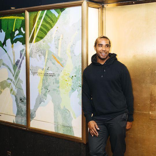 Artist Hugo McCloud stands in front of his artwork on display at Rockefeller Center