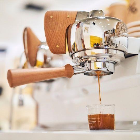 Espresso dripping into a glass at % Arabica