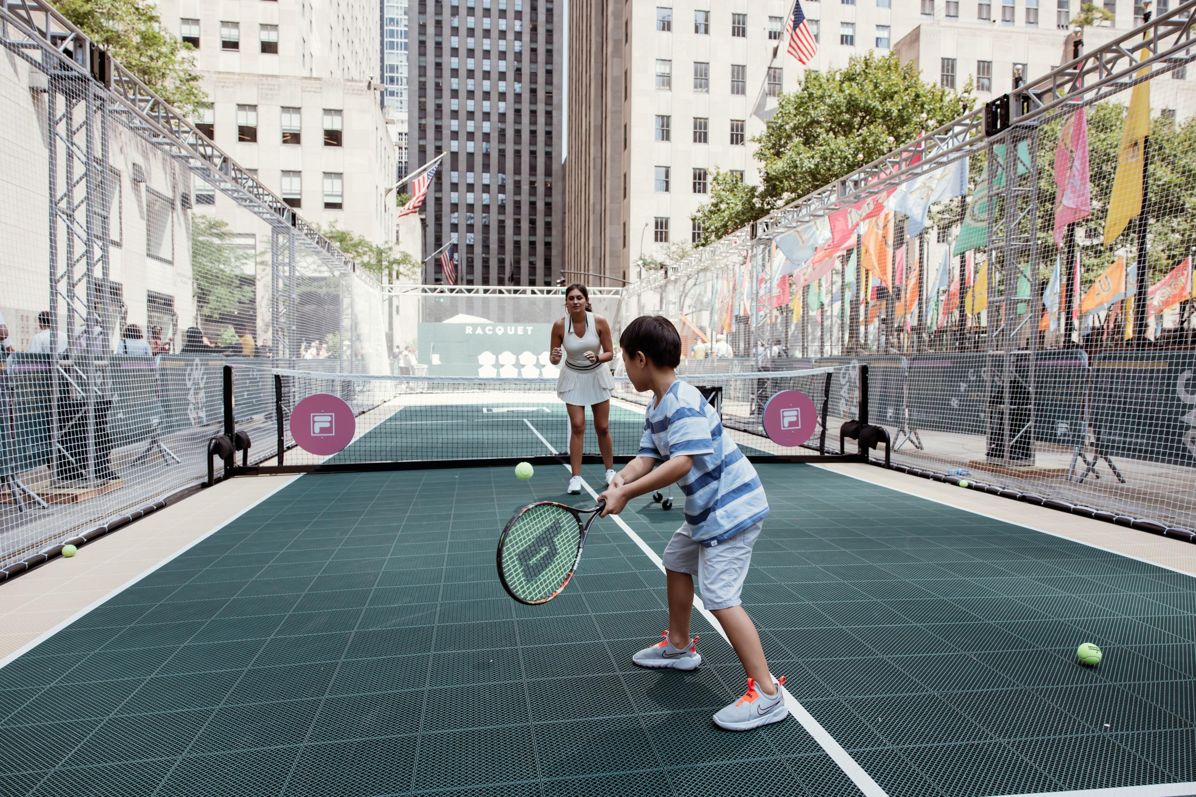 two people playing tennis at rockefeller center