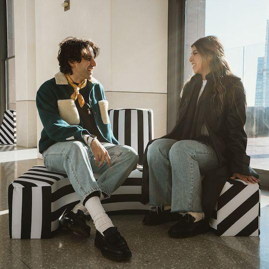 Two people sitting on a piece in Kris Moran and Martin Duffy's interactive art installation at Top of the Rock