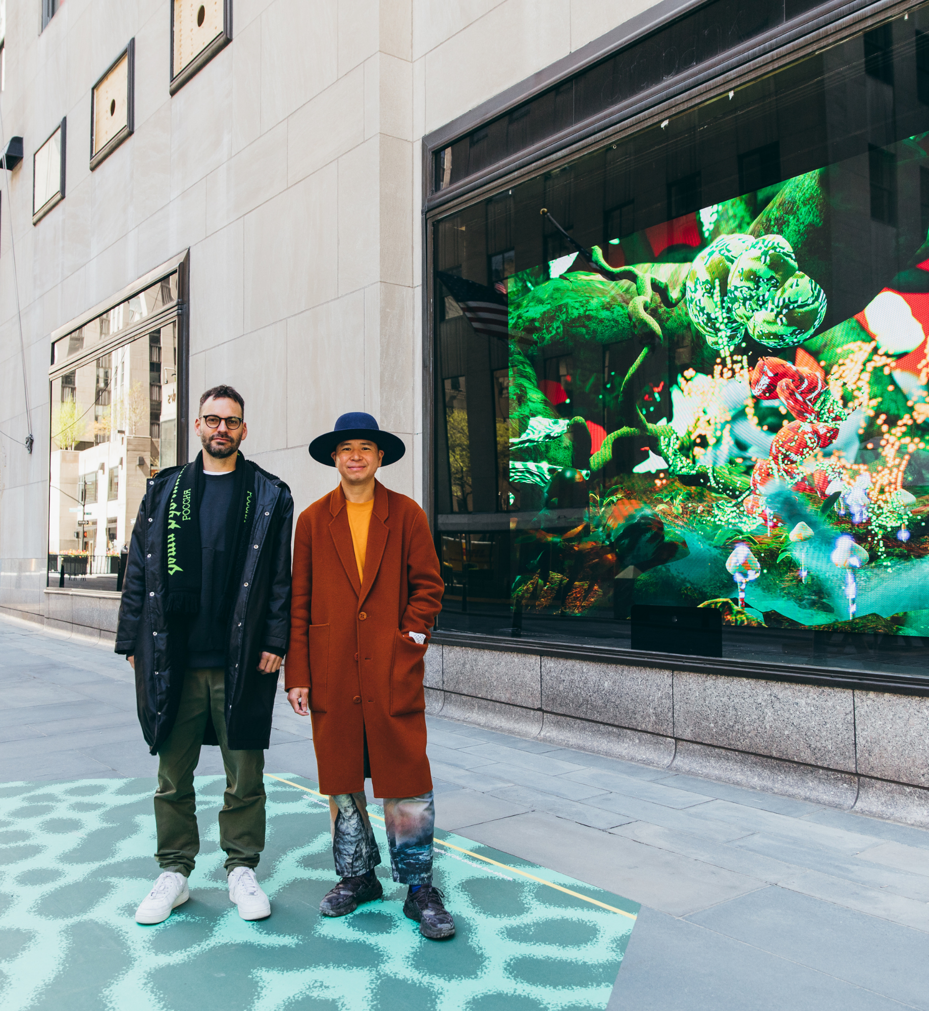 Artists, Tin Nguyen and Ed Cutting stand in front of their Life Forces Installation at Rockefeller Center