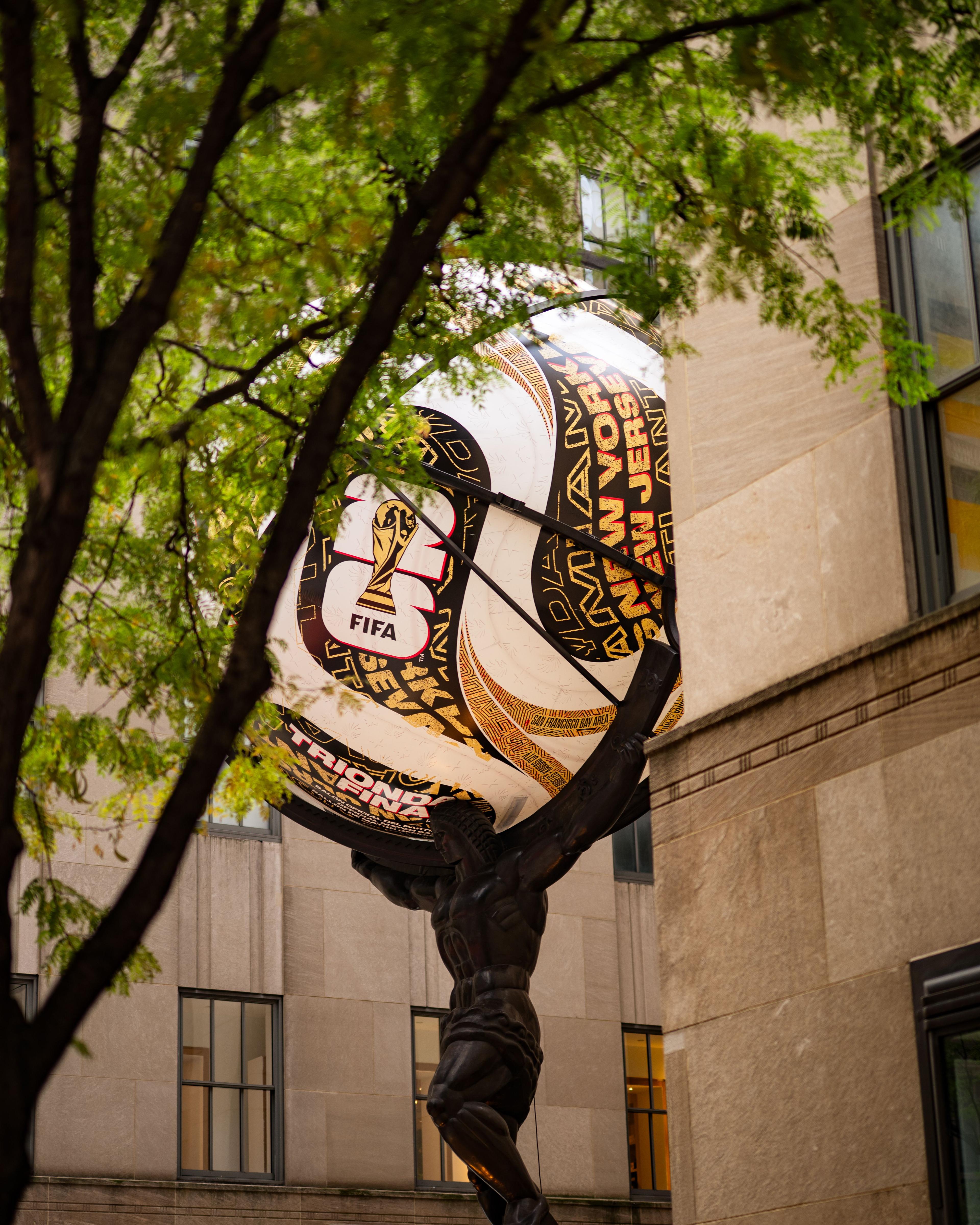 atlas statue with adidas soccer ball installation