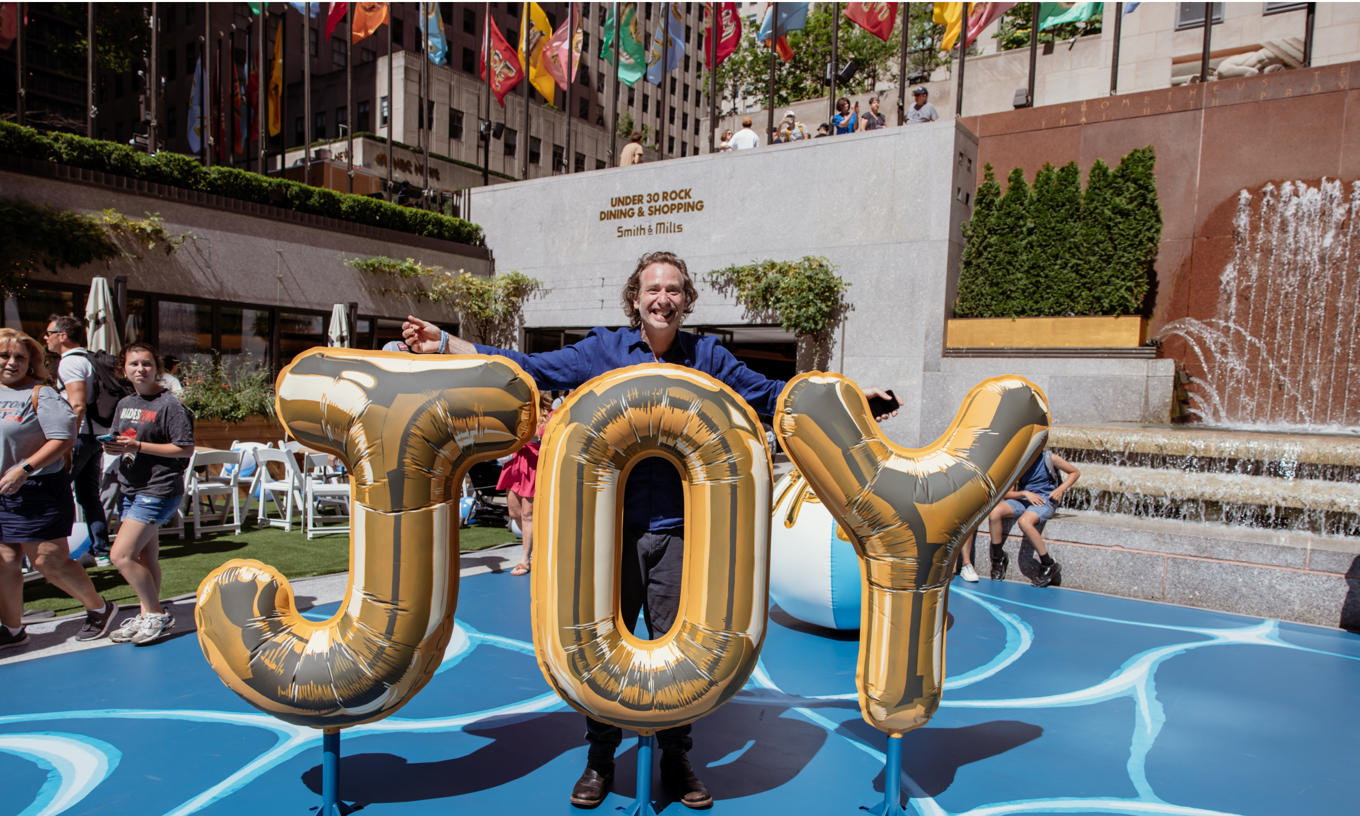 Artist Joel Mesler standing behind a sculpture at "Pool Party," his public art installation at Rockefeller Center