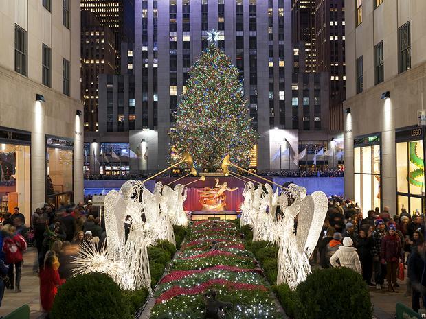 From the point of view of the trumpt playing angels on the Rockefeller Plaza, the tree sits, lit before the Plaza.