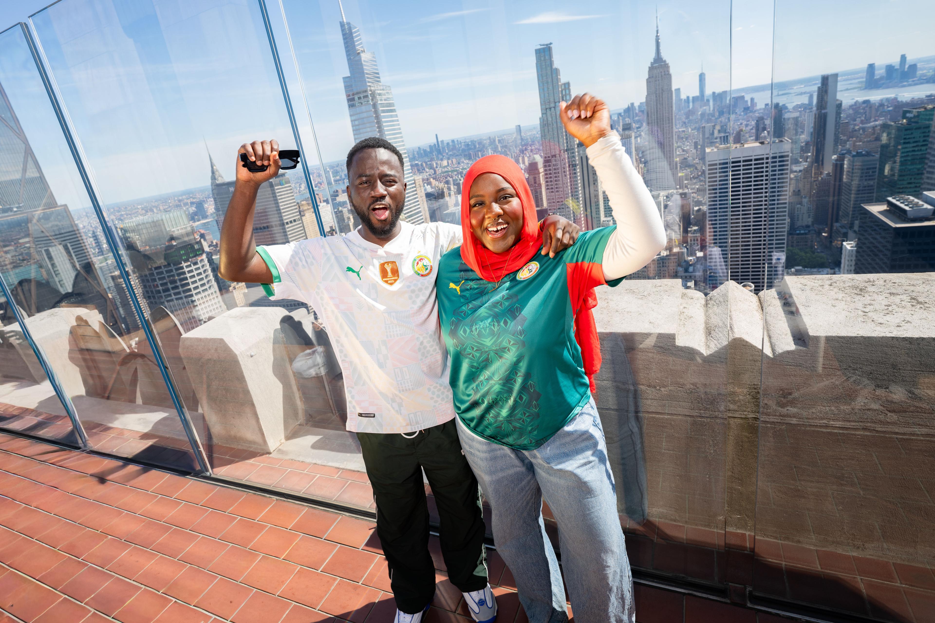 two soccer fans at top of the rock