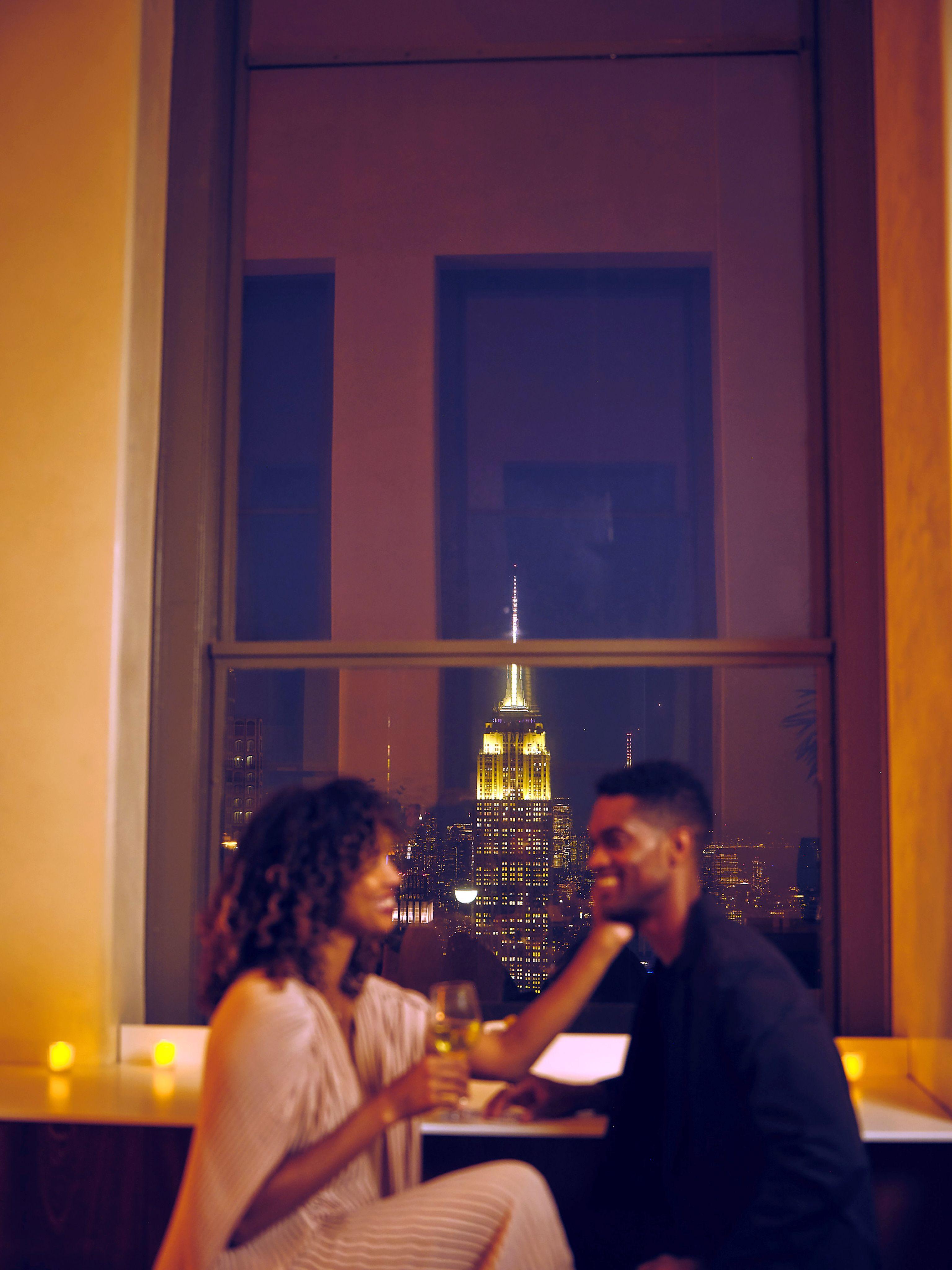 Two people in front of a window overlooking New York City